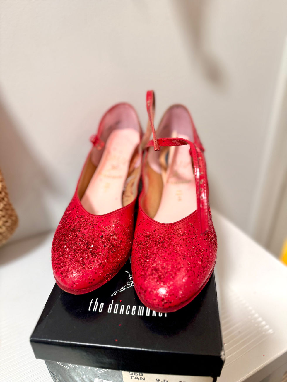 Red glittery shoes on a black box.