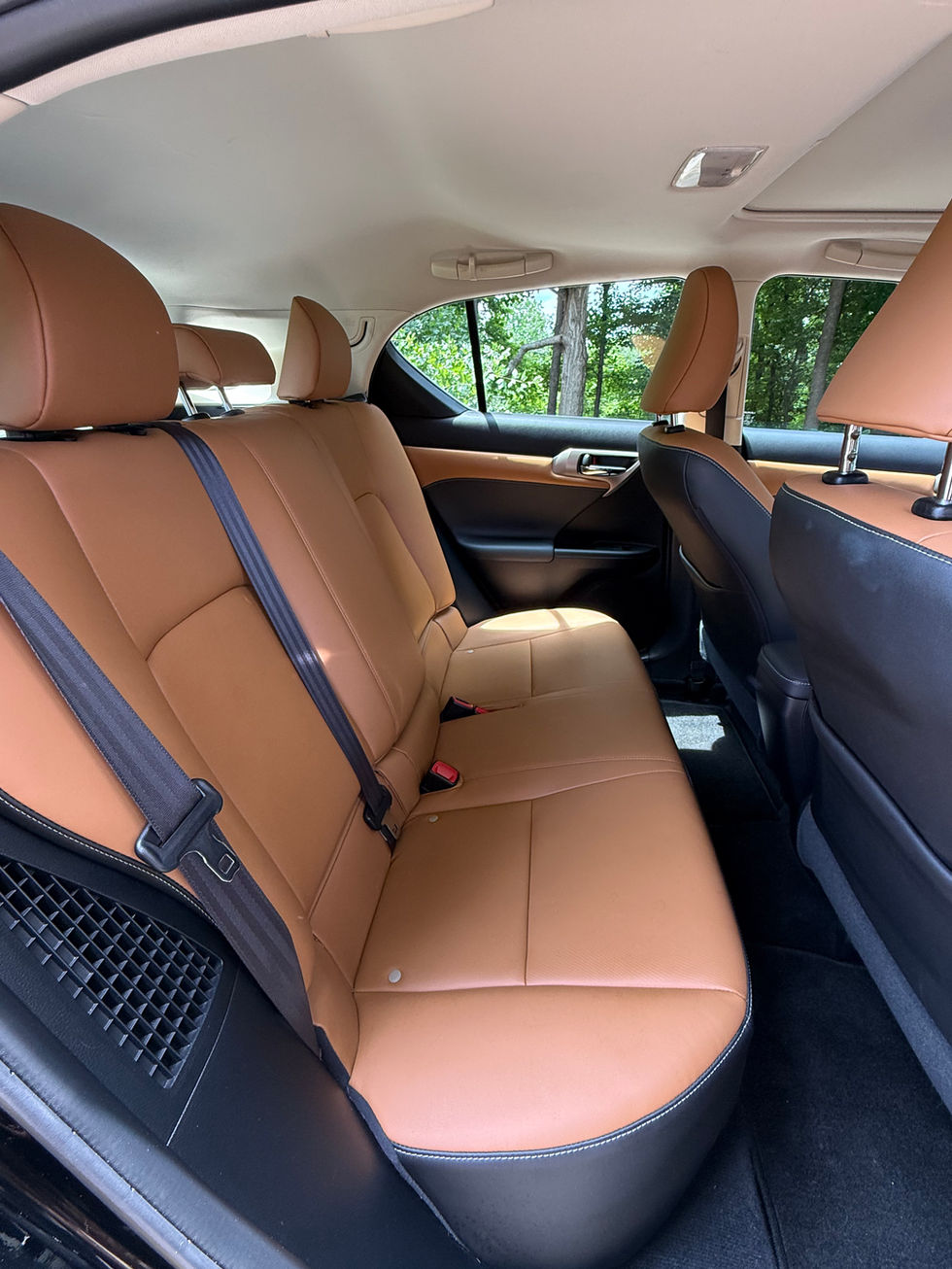 Car interior with brown leather seats, rear view.