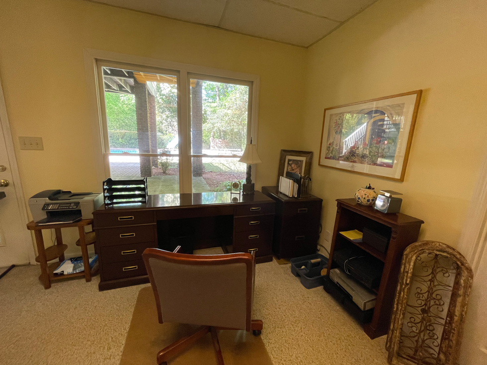 a home office with a desk and chair and a picture on the wall