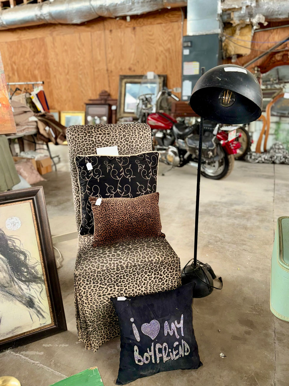 Vintage salon chair with hair dryer and decor items.