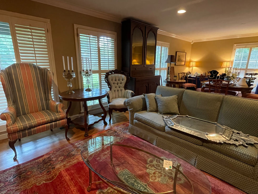 a living room with a couch and chairs and a glass coffee table