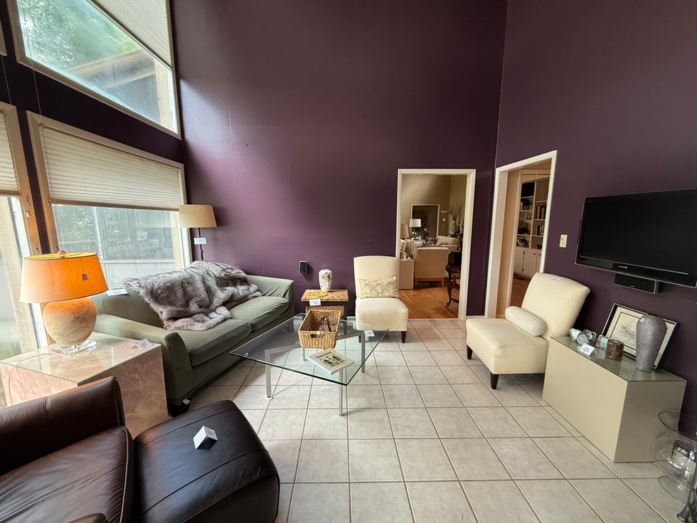 a living room with purple walls and white furniture