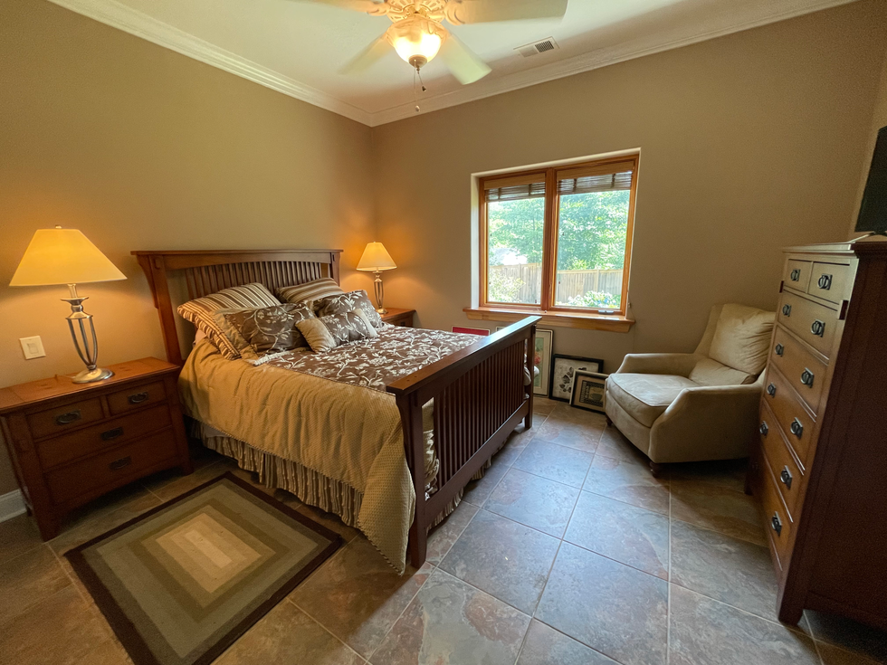 a bedroom with a large bed and a chair