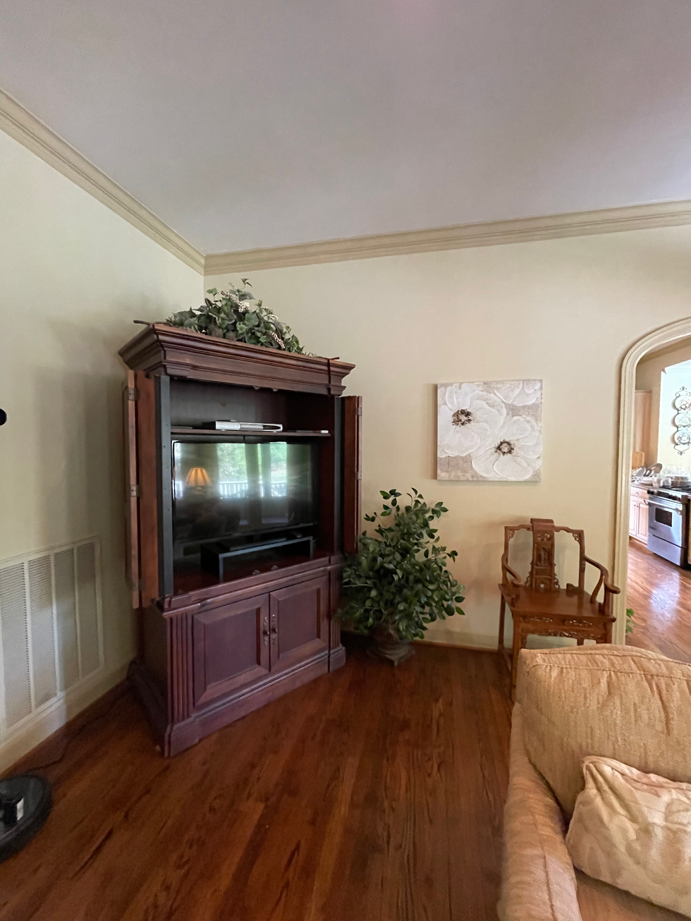 a living room with a large entertainment center and a painting on the wall