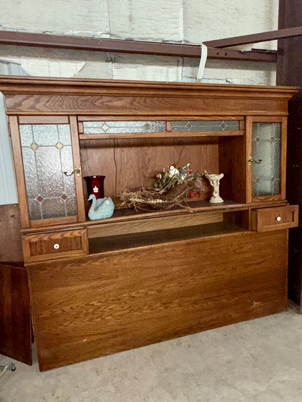 Wooden cabinet with decorative items displayed inside.