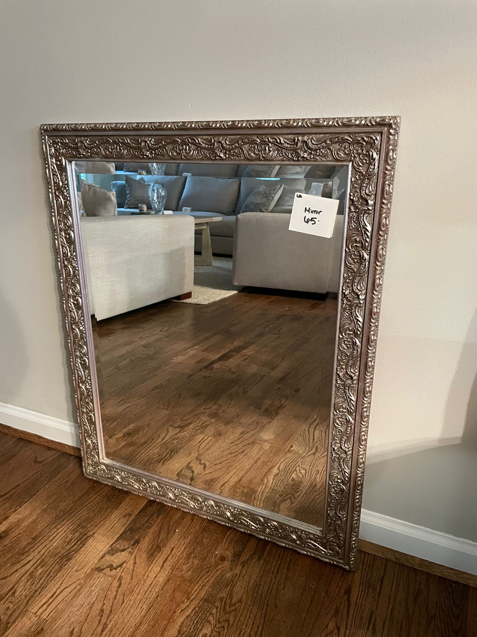 a mirror with a silver frame has a note on it that says " near 45 "