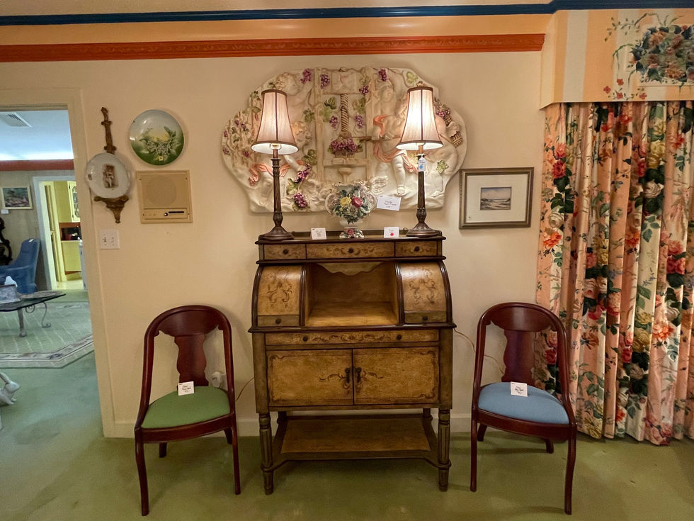 a room with two chairs and a desk with two lamps on it