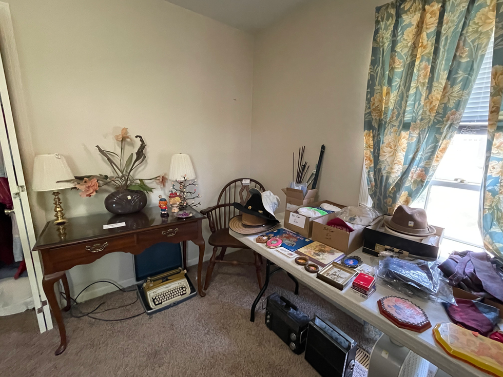 a room with a table full of items including a box that says ' hats ' on it