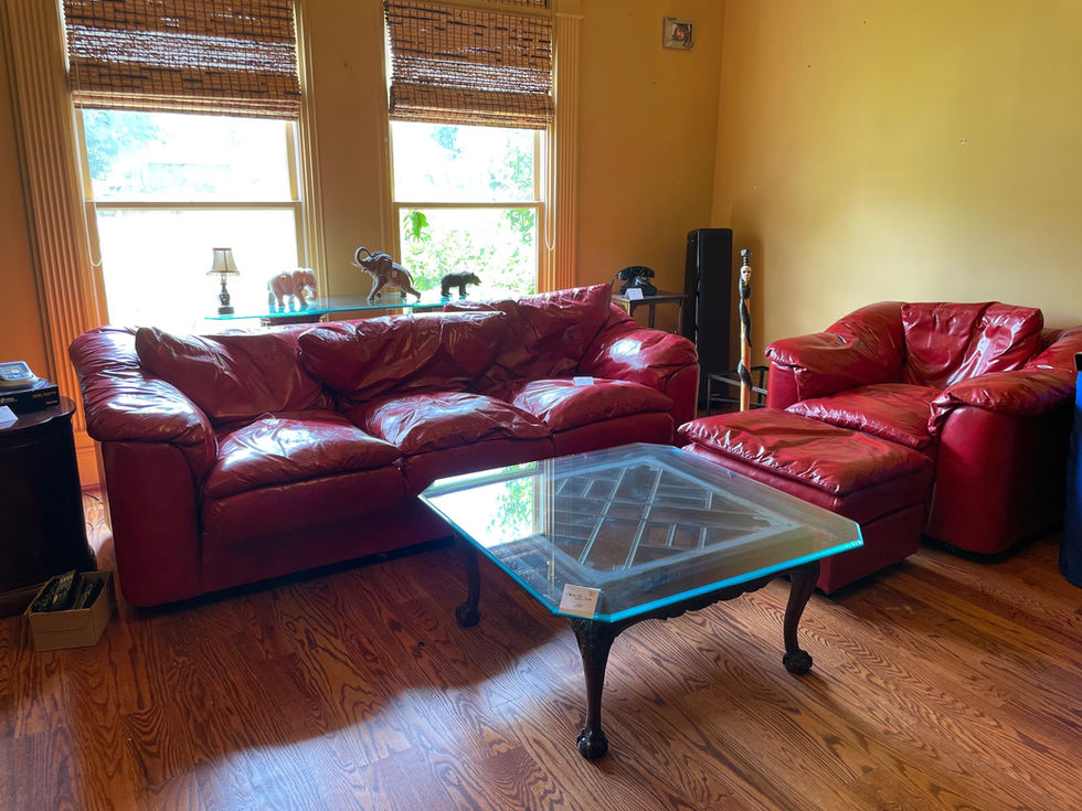 a living room with red leather furniture and a glass coffee table