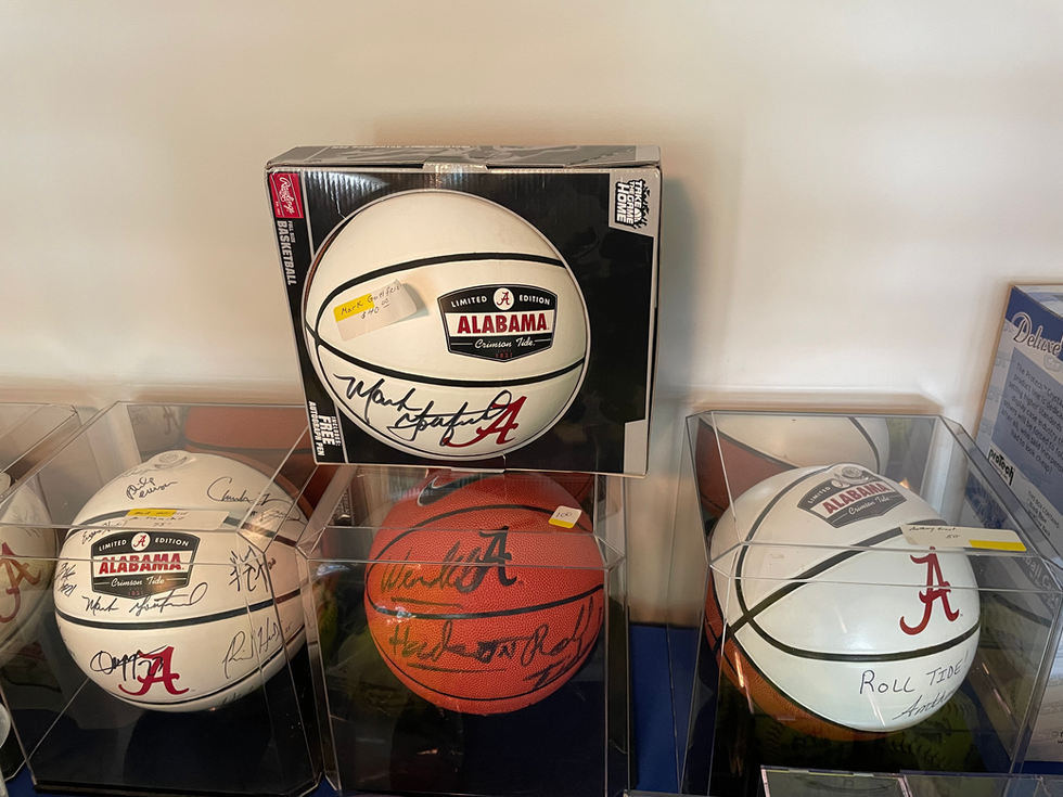 several alabama basketballs are displayed in clear cases