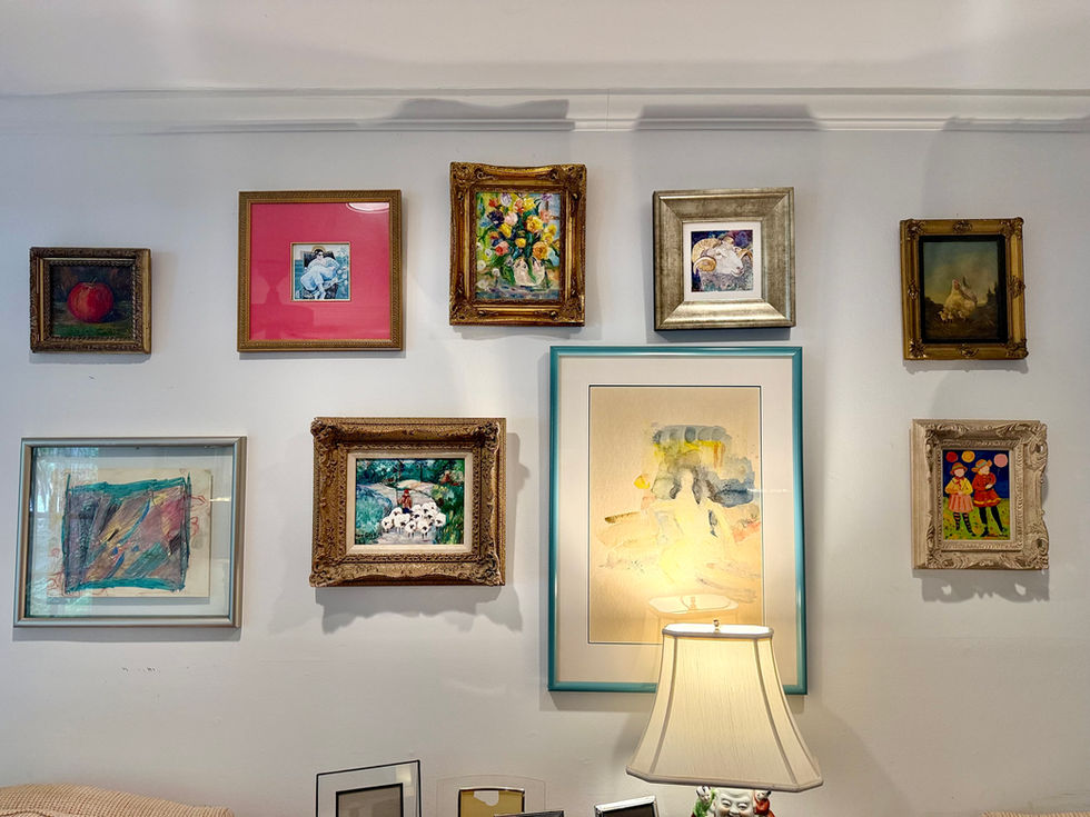 Wall with framed art and a lamp below.