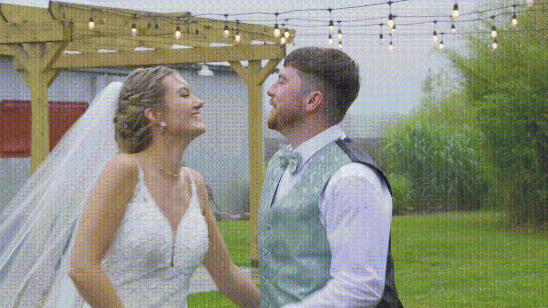 Bride and groom kissing in the rain during their Michigan wedding