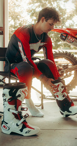 Jett Lawrence putting on Alpinestars MX27 motocross gear and Tech 10 mx boots before riding.