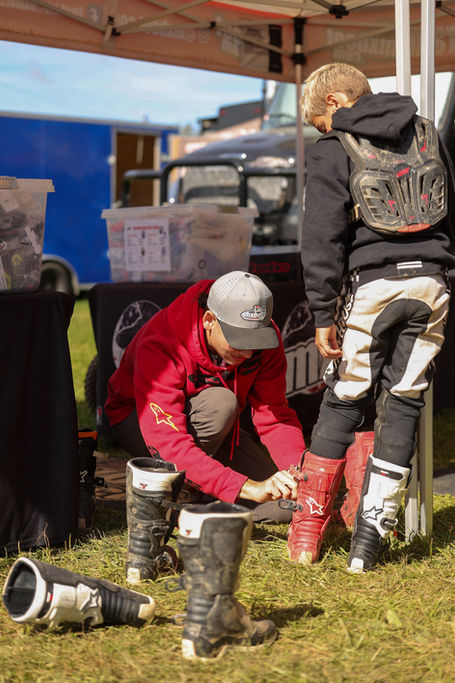 Boot Specialist Sam helping a rider try on new motocross boots at the track