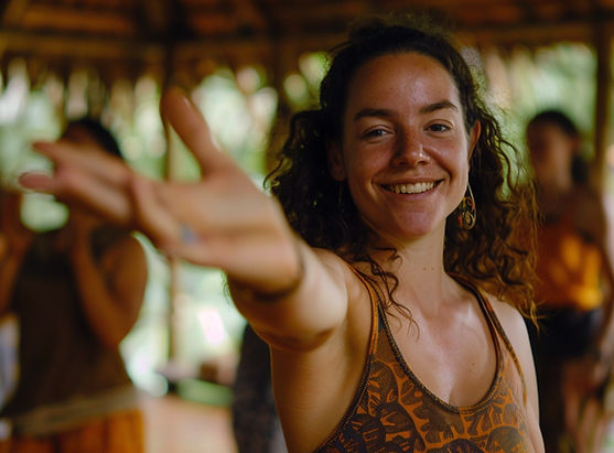 A woman smiling at a retreat with her hand stretched out toward the camera.