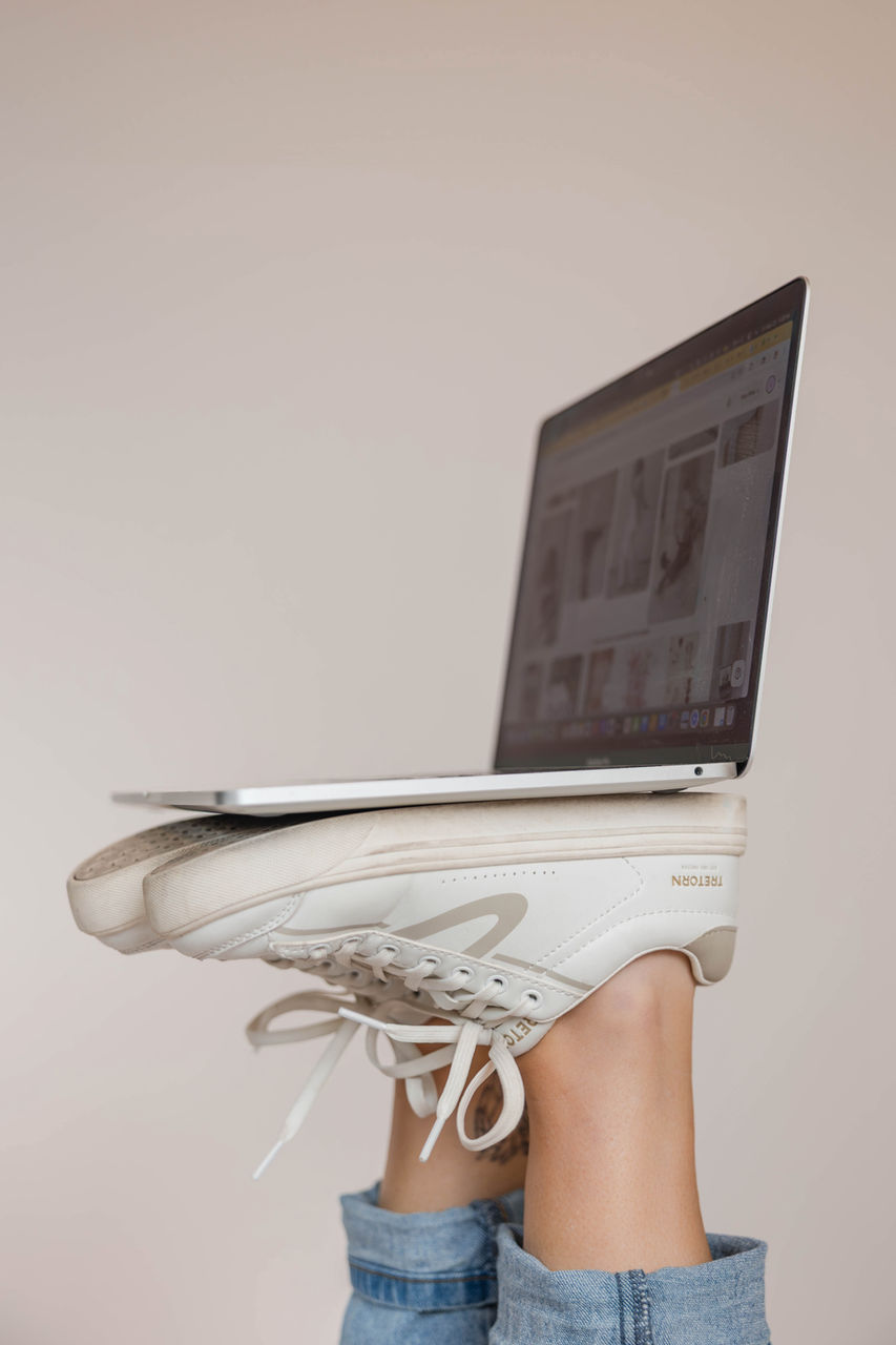 Laptop balanced on feet in sneakers