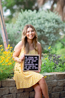 Senior girl sitting among flowers at South Texas Botanical Gardens in Corpus Christi, Texas
