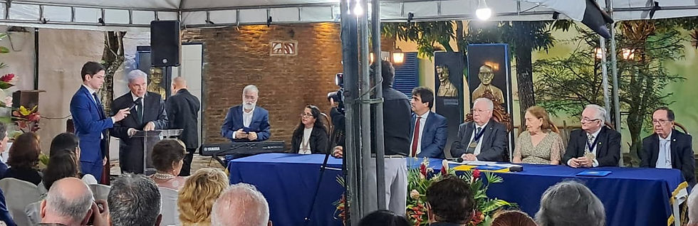 Foto: Novel Acadêmico Gil Messias proferindo seu discurso de posse e visão geral da Mesa dos Trabalho da Solenidade, da esquerda para direita: Acad. Ana Almeida (Pres. ASLAC), Acad. Thélio Farias (Pres. ACL), Presidente da APL Acad. Severino Ramalho Leite, Acad. Ângela Castro (ex-presidente da APL), Acad. Eitel Santiago (Pres. da APLJ) e Acad. Wilberto Trigueiro (Pres. APMED).