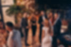 Group of people in formalwear communicating and smiling while spending time on luxury part