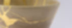 Kintsugi beige tea ceremony chawan. Gold cracks restoration on old Japanese pottery restor