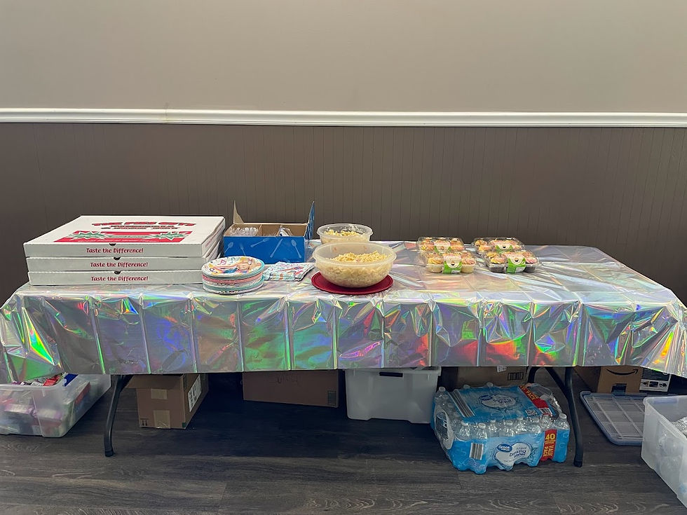 Jojo Siwa Party Food Table with sheet pizzas, pasta salad, macaroni salad, plates, napkins, silverware, and water