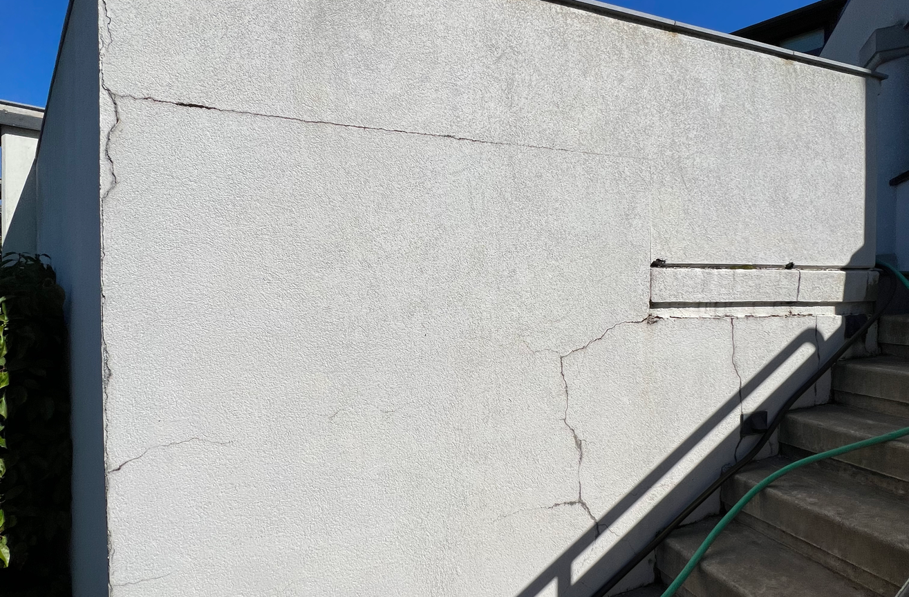 Expert stucco painting technique—spraying and back-rolling for even coverage in Kirkland, WA.