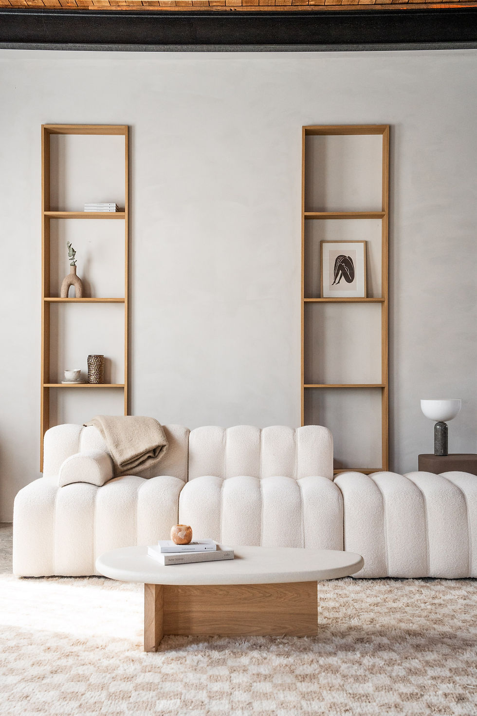 The Haven Studio, Living room with white sofa, coffee table, wood shelves