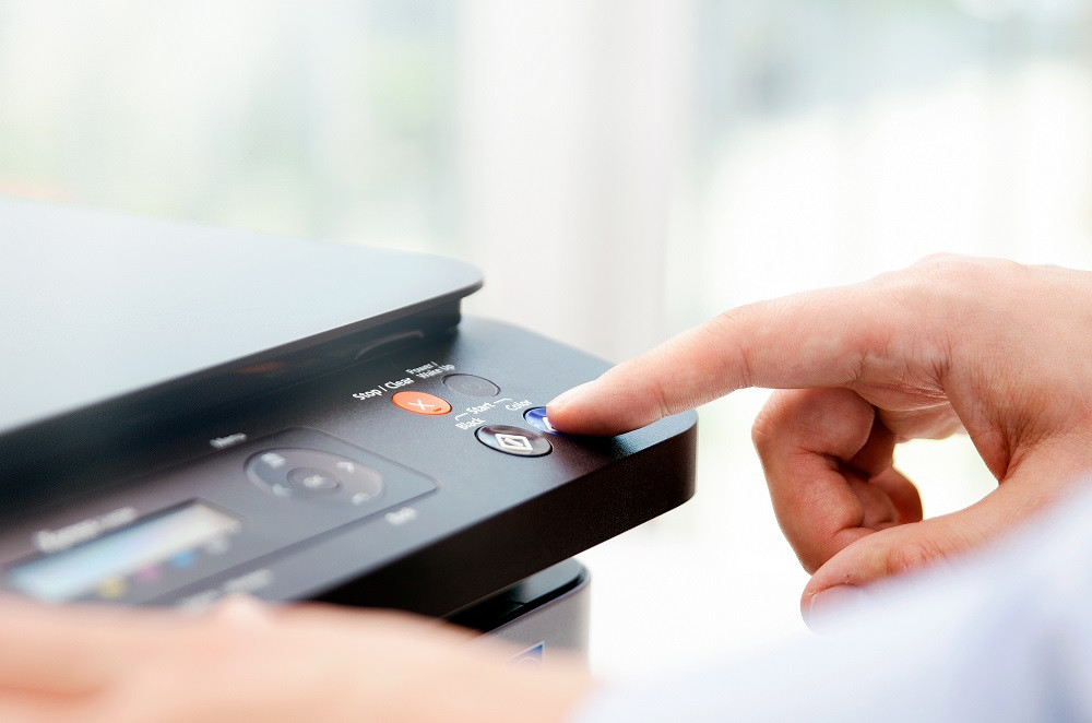 Finger pressing button on copy machine
