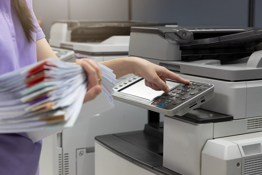Woman Hold a Stack and Papers and Using Printer at Work