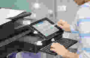 Office worker using screen and keyboard on printer