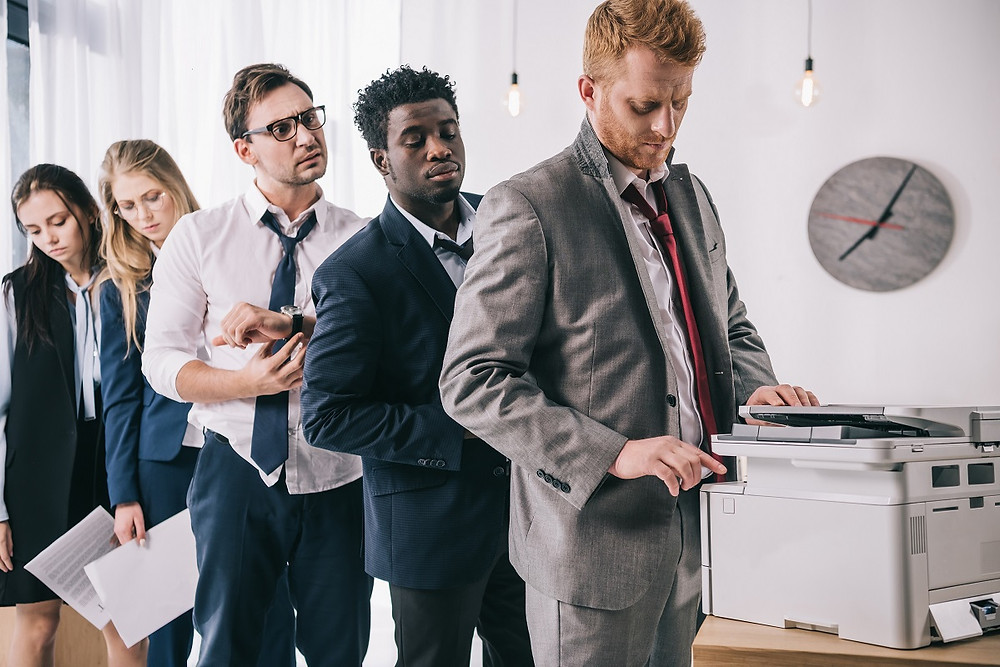Office Employees Waiting to Use Copier Machine