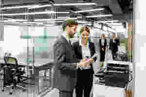 Man and woman standing at office printer
