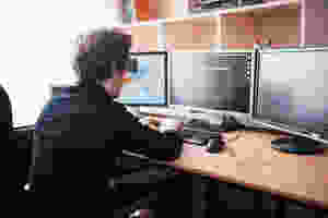 Man with three computer monitors