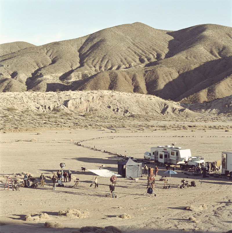 Film shoot in desert with caravan, trucks, tents and equipment