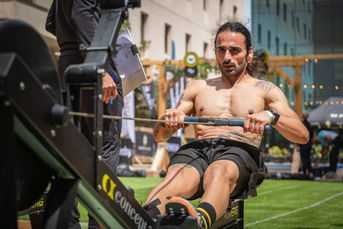 Muscular man exercising on a rowing machine