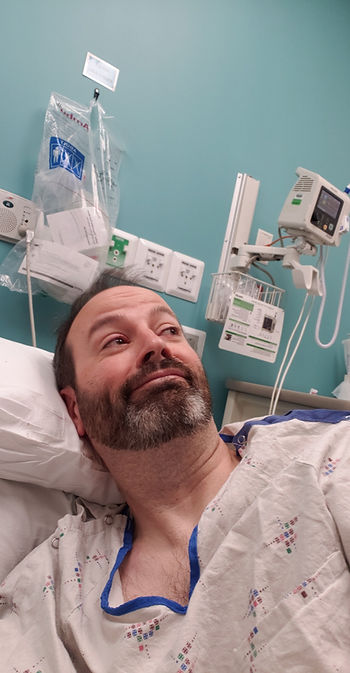 Man lying in hospital bed looking away.