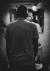 homme se regarde dans le miroir de sa salle de bain, concentration avant mariage noir et blanc