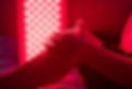 Closeup of sore leg of a person treating with the red light therapy panel.jpg
