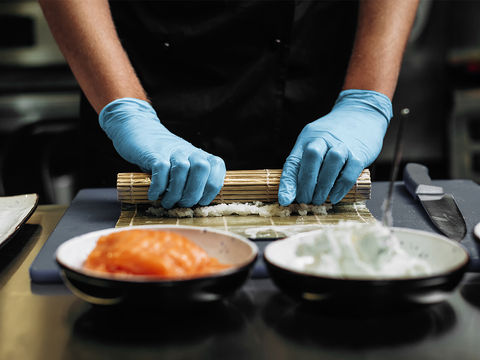 壽司師傅正在製作壽司。餐飲業者配戴食品級NBR手套來製作餐點,落實食品安全與衛生。
