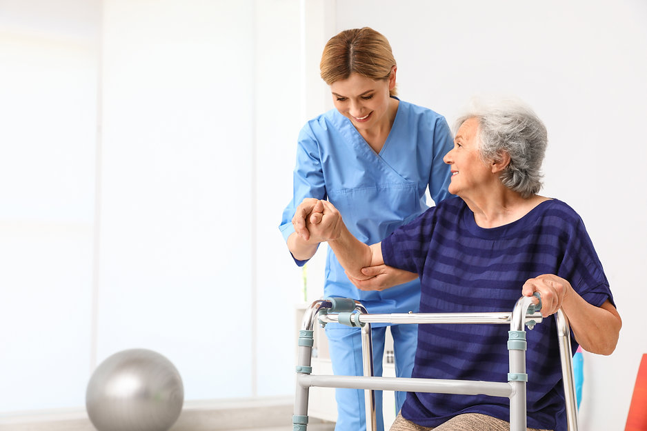 Caretaker helping elderly woman with wal