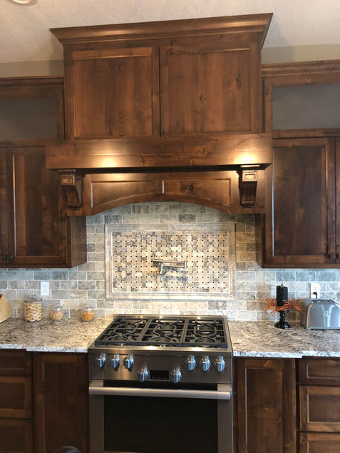 Kitchen backsplash tile with built-in pot filler and custom cabinetry.