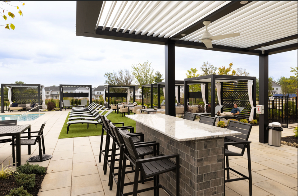 StruXure Cabana X outdoor cabana providing shade beside a swimming pool for modern resort-style living.