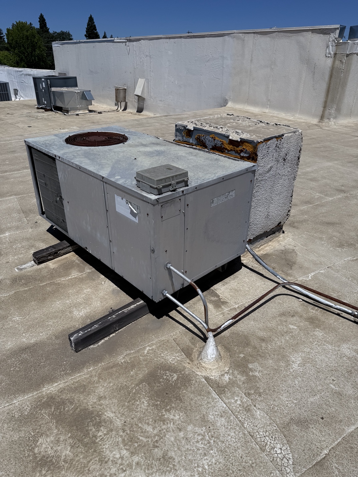 Existing rooftop HVAC equipment before removal at the Madison commercial project