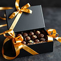 black gift box with golden ribbons and chocolates inside.jpg