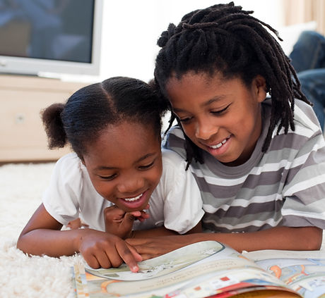 Pensive children reading a book lying on