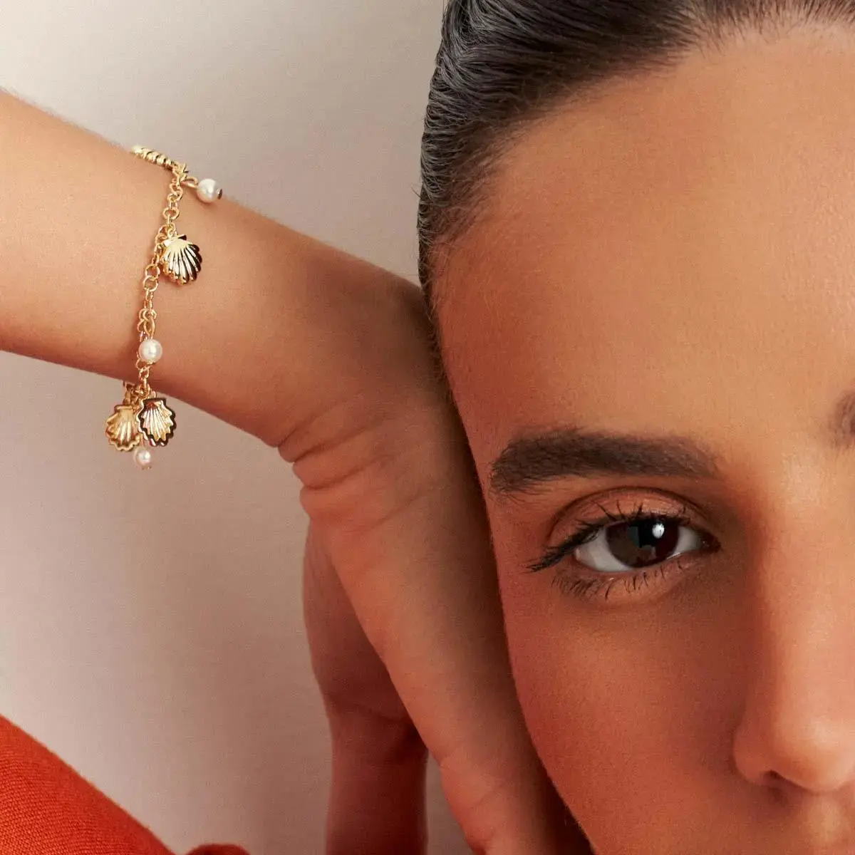 PULSEIRA COM PÊNDULOS DE CONCHA E PÉROLAS BANHADA A OURO
