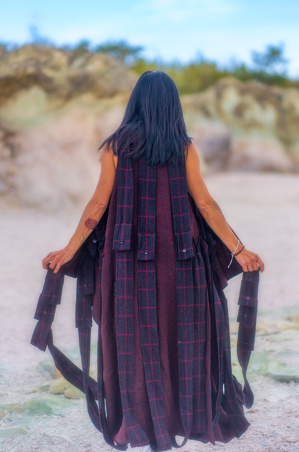 Хубавица носи дълго вълнено елече с много колани и ресни на гърба