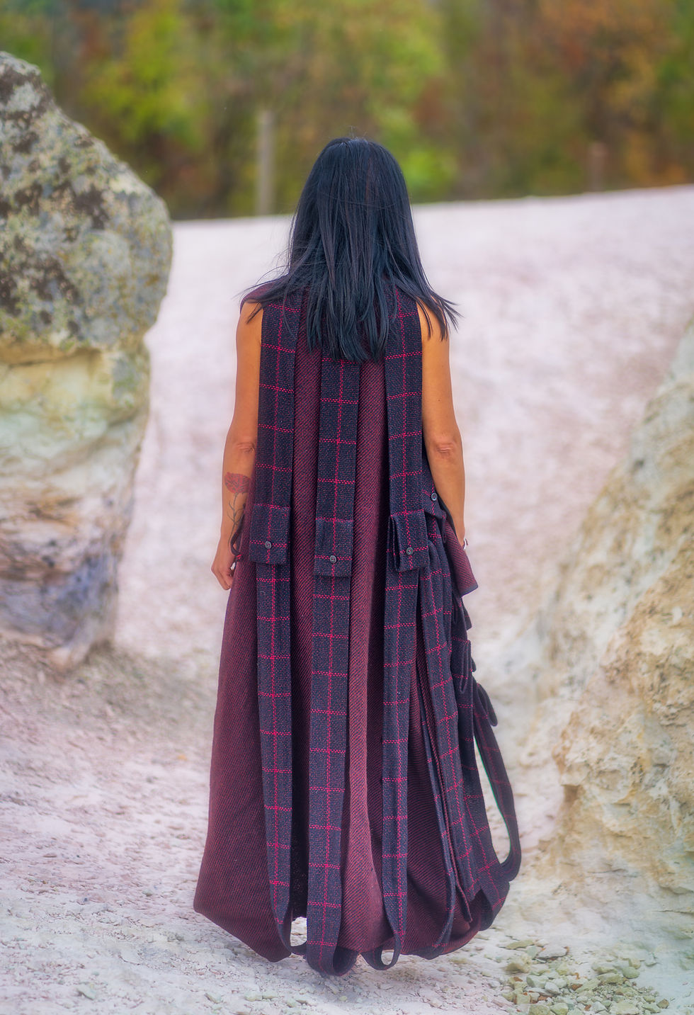 Хубавица носи дълго вълнено елече с много колани и ресни на гърба