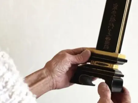 小さなお位牌を持つ女性