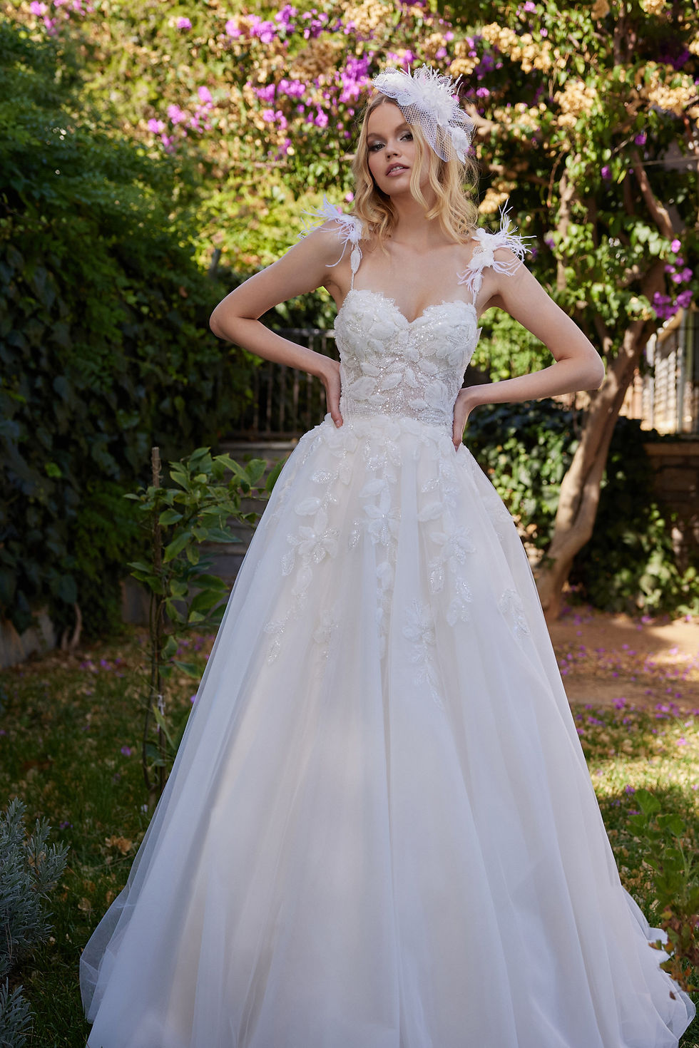 Kır düğünü konseptine uygun, eteği çiçek aplikeli ve ışıltılı A kesim gelinlik modeli.